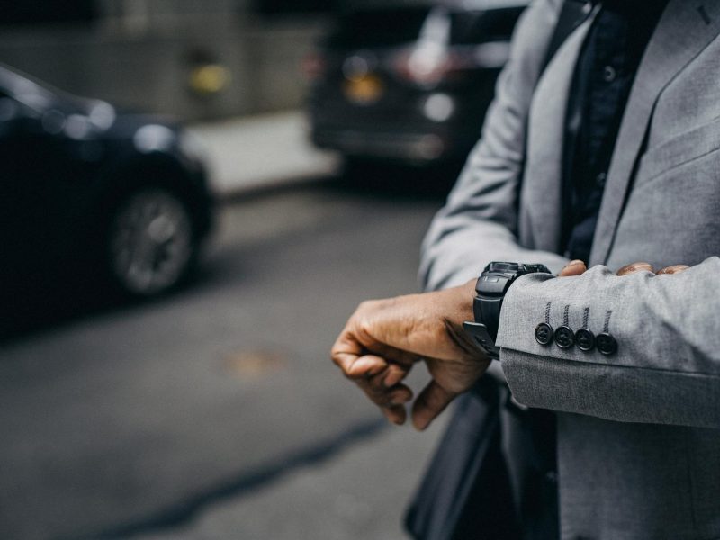 faceless african american entrepreneur looking at wristwatch